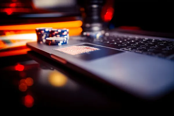 A woman smiling while playing online games on her laptop, surrounded by neon casino elements, showcasing GEMJLL’s diverse game collection.