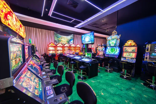 A man celebrating a winning moment on his laptop while gaming symbols float around him, capturing the excitement of GEMJLL games.