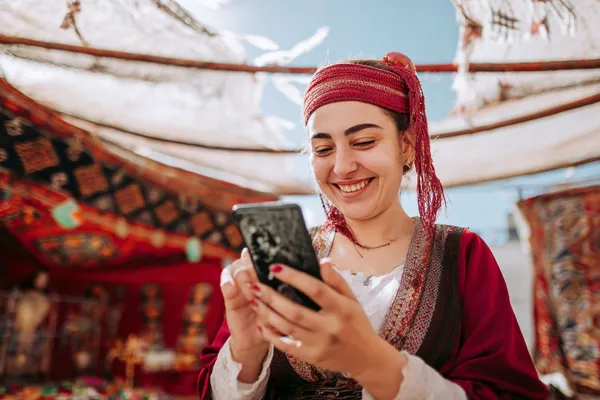 A player using their smartphone during a festive local event, representing GEMJLL’s fully mobile-friendly casino.